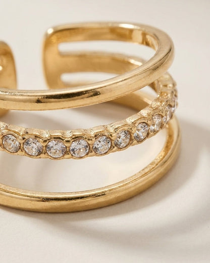 Gold-toned multi-band ring featuring a central row of round, clear stones.