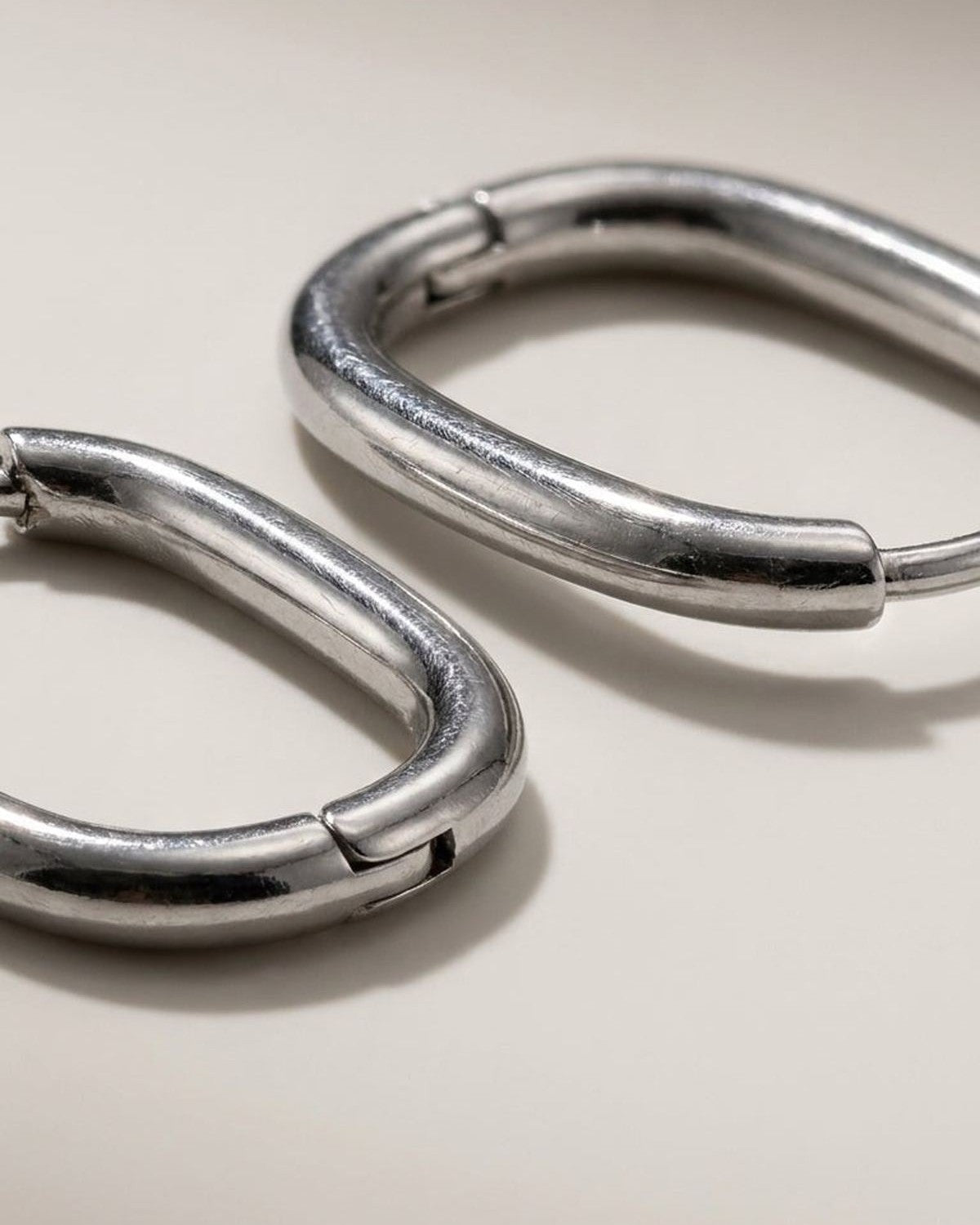 Silver hoop earrings by House of Lily featuring a chunky, minimalist oval design with a smooth, polished finish.