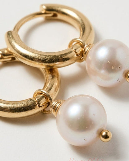 Main Character Pearl gold hoop earrings with dangling pearls.
