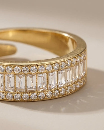 Gold ring featuring a center row of baguette-cut stones bordered by two rows of small round rhinestones.