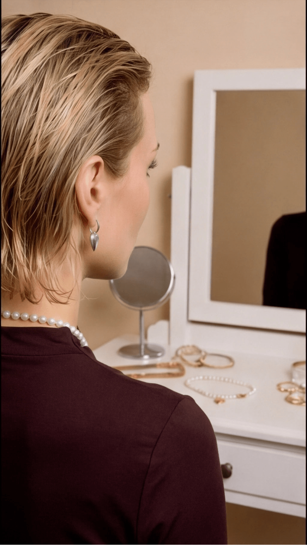 Model wearing silver Coquette Heart Hoops, a small silver heart charm suspended from a minimalist hoop earring.
