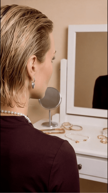 Model wearing silver Coquette Heart Hoops, a small silver heart charm suspended from a minimalist hoop earring.
