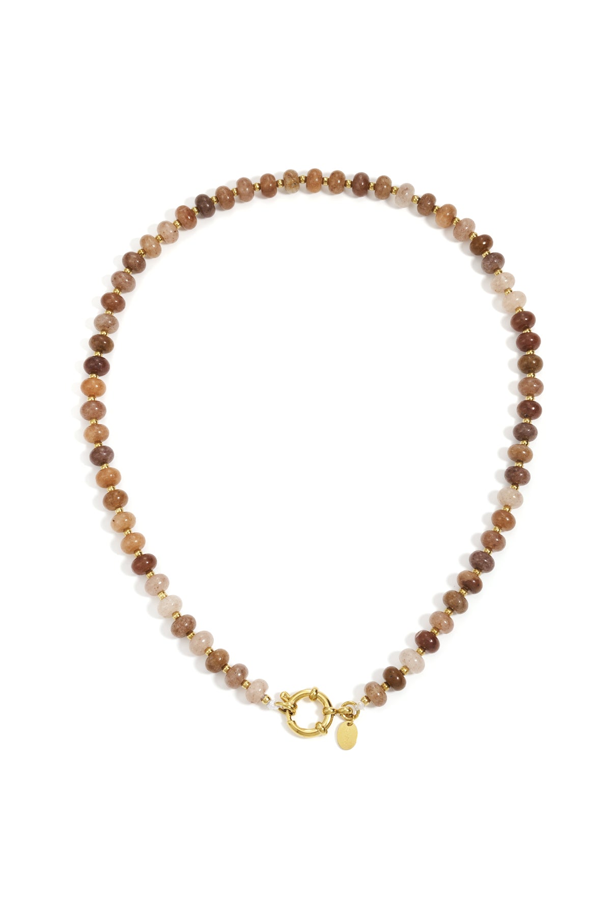 Close-up of a peach and neutral tone stone beaded necklace with gold beads and toggle clasp