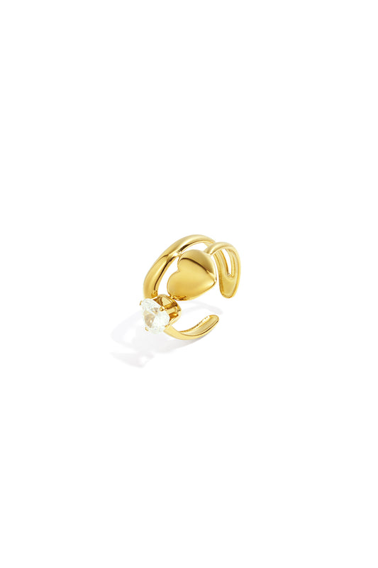 Close-up of a gold adjustable ring with a heart and clear gemstone on white background