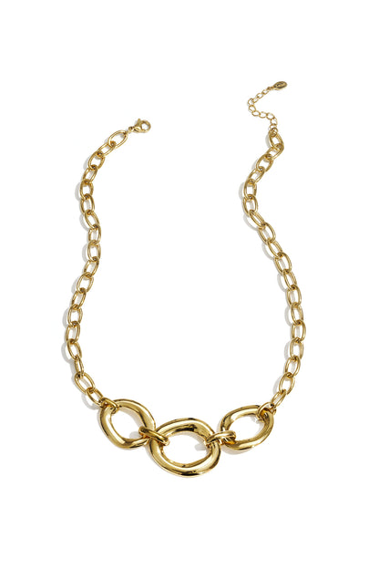 Gold chunky link necklace with three oversized rounded links and adjustable chain laid flat on white background