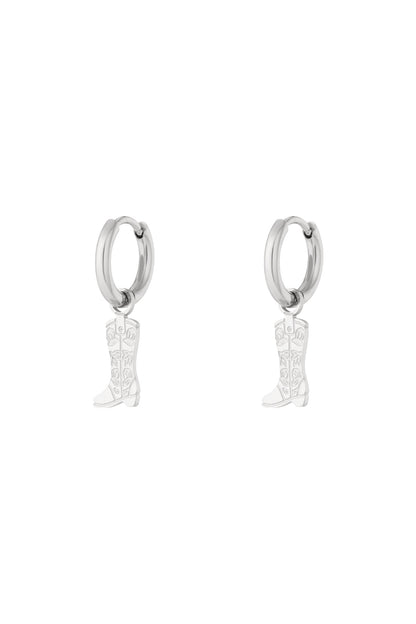 Pair of silver hoop earrings with hanging cowboy boot charms featuring floral detail on white background