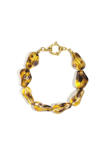 Amber-colored irregular-shaped acrylic bead bracelet with a gold-tone toggle clasp on a white background