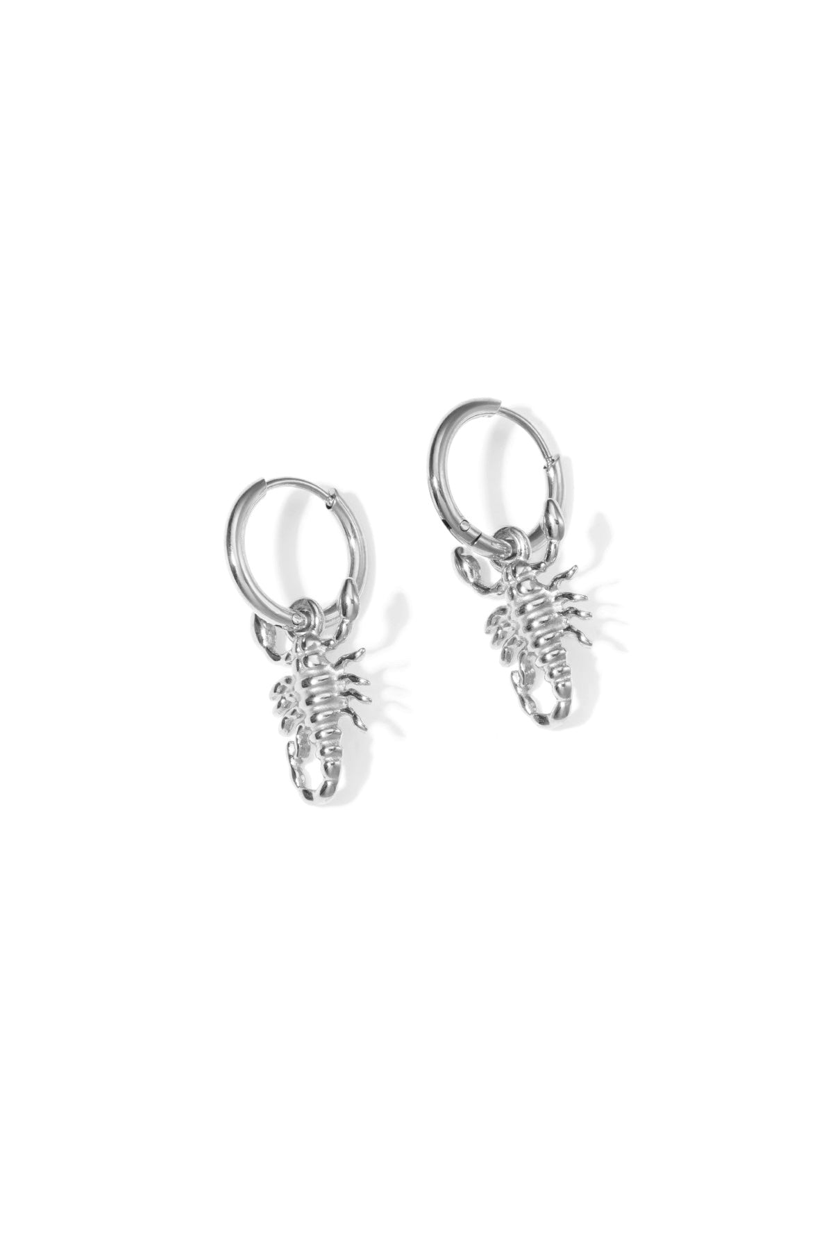 Pair of silver hoop earrings each with a small detailed scorpion charm on a white background