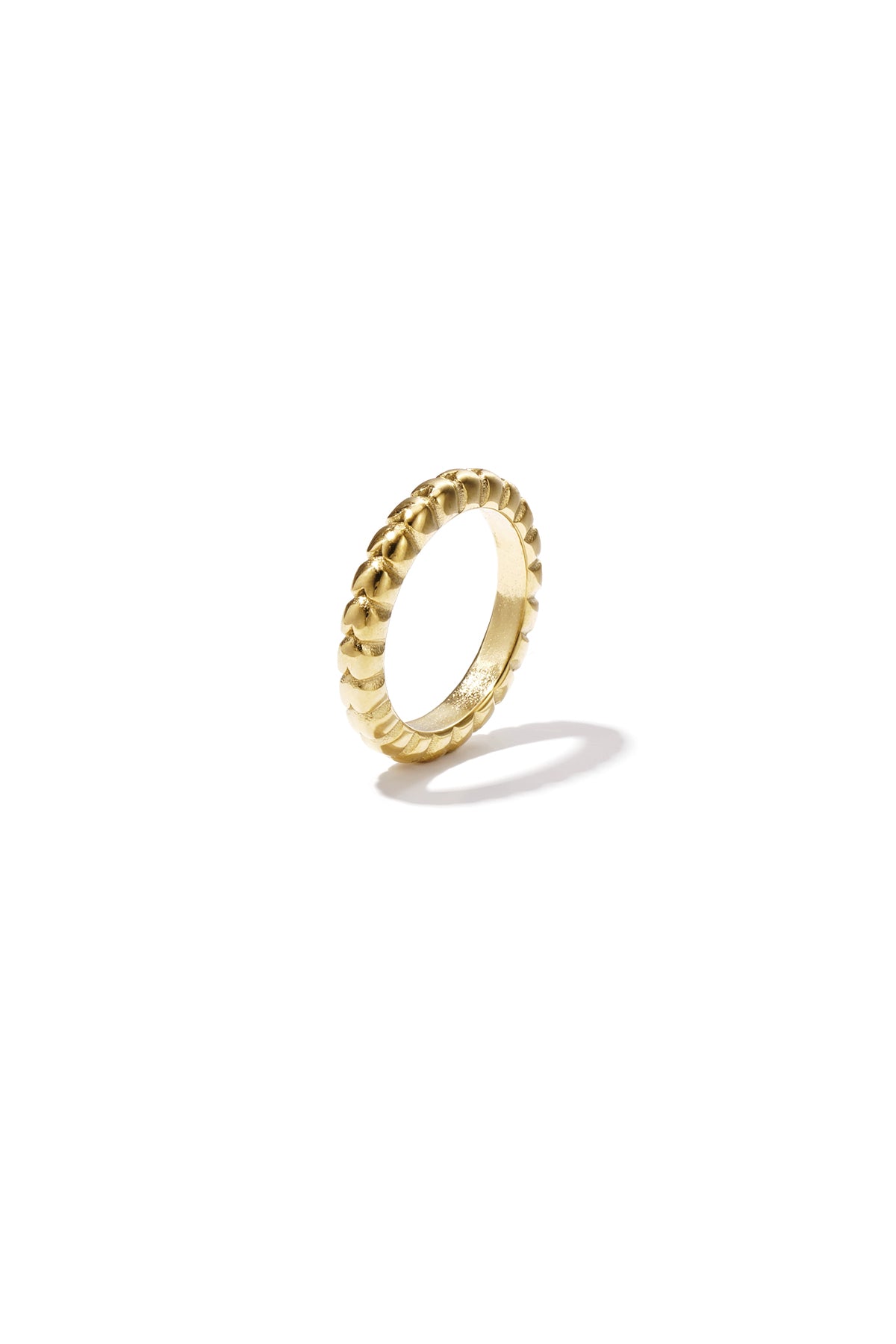 Close-up image of a single textured gold-tone ring standing upright on a white background casting a soft shadow
