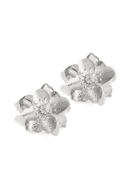 Pair of silver flower statement earrings with rhinestones on white background