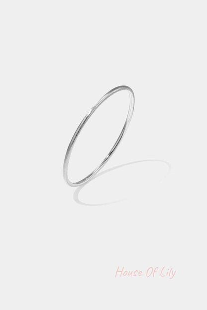 Minimalist silver 3mm circle bangle bracelet on white background