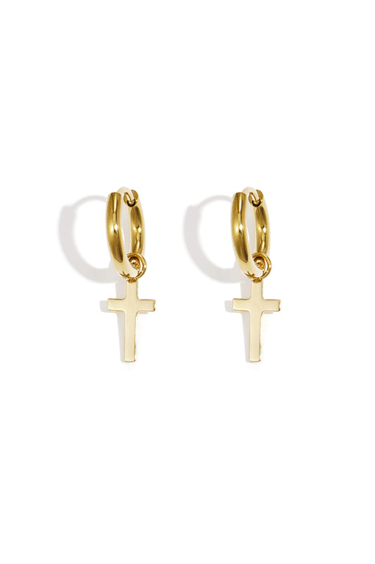 Pair of gold hoop earrings featuring delicate dangling cross pendants on a white background