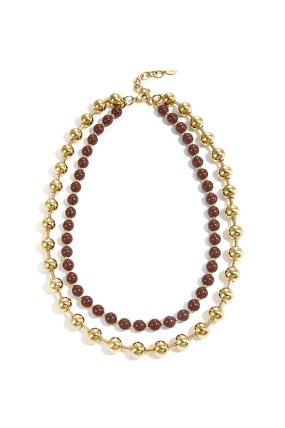 Layered necklace set featuring chunky gold beads and smaller chocolate brown beads arranged flat on white background