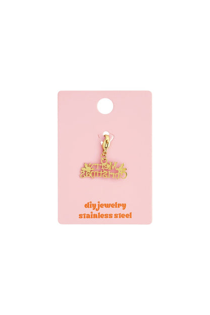 Gold-tone stainless steel "Merry Christmas" charm with lobster clasp on a pink display card.