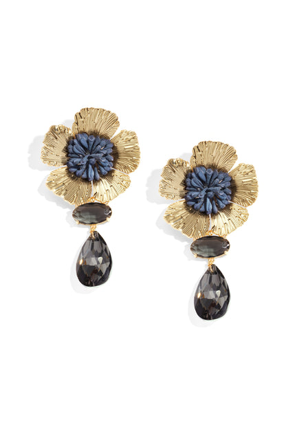 Pair of gold plated floral earrings featuring deep blue resin centers and smoky faceted crystals, photographed on white background
