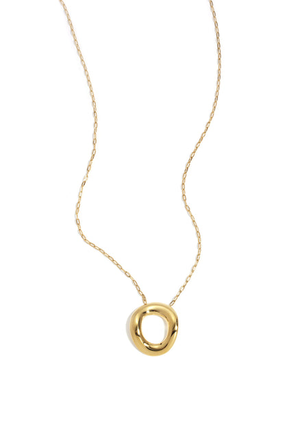 Gold necklace with a chunky, irregular circular pendant on a delicate chain against a white background