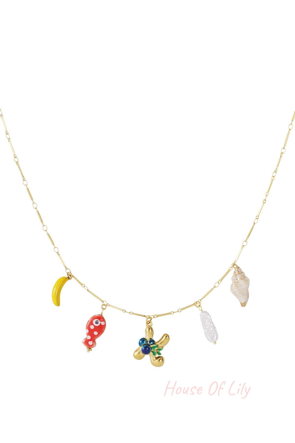 Gold chain necklace with assorted charms: banana, red polka-dot fish, initial K, pearl, and seashell.