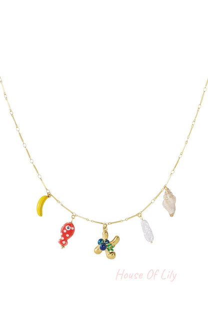 Gold chain necklace with assorted charms: banana, red polka-dot fish, initial K, pearl, and seashell.