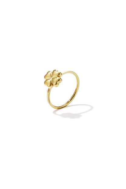 Close-up of a gold-tone ring featuring a four-leaf clover design with smooth rounded leaves on white background