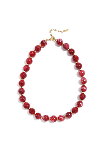 Brown marbled chunky beaded necklace with gold spacer beads and adjustable gold chain on white background