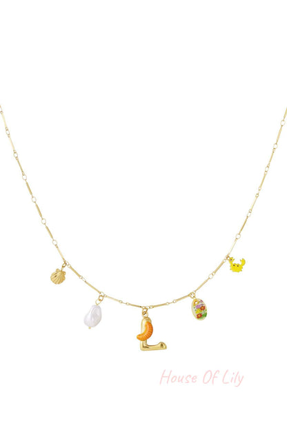Gold chain necklace featuring an 'L' initial pendant with a small orange slice, pearl, shell, crab, and floral charm.