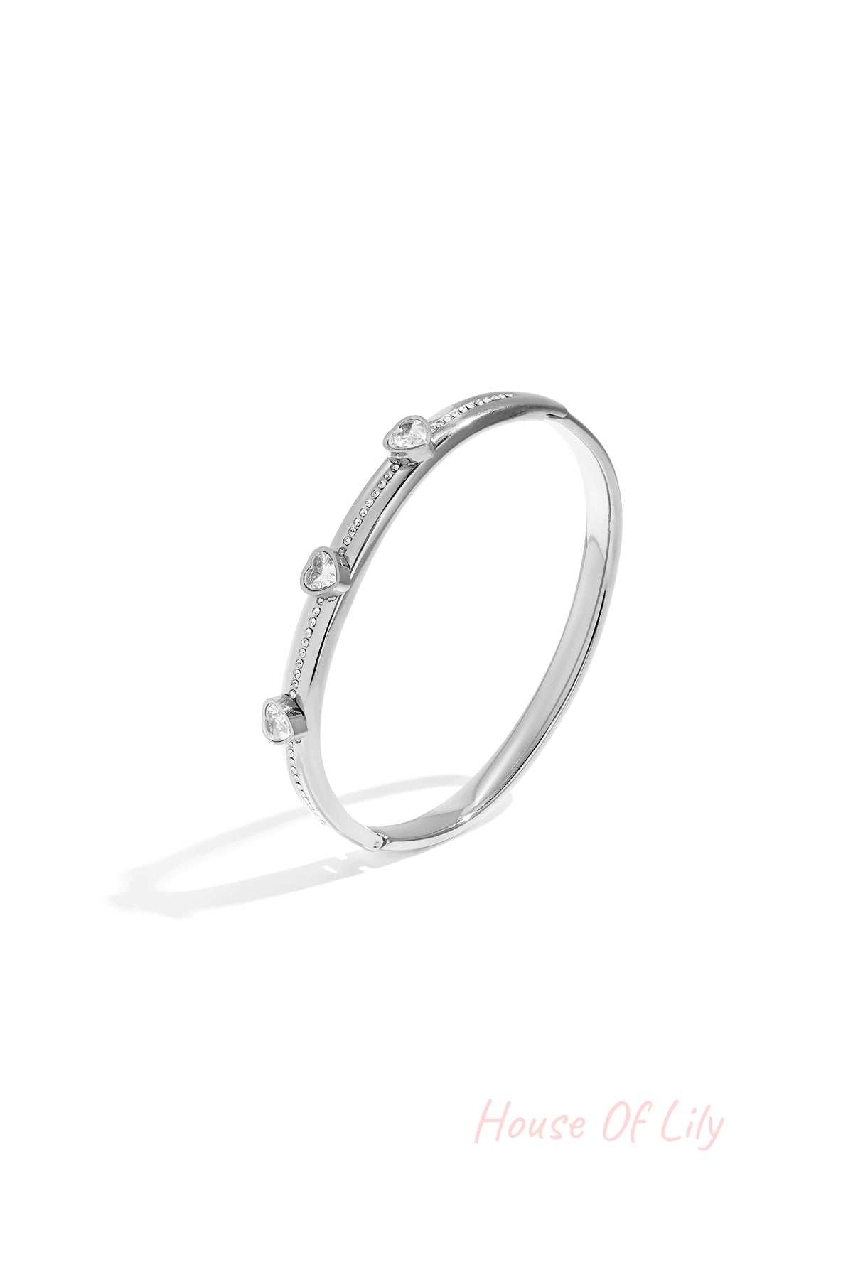 Silver tone heart crystal accent bangle isolated on white background