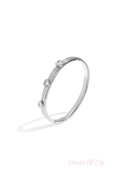 Silver tone heart crystal accent bangle isolated on white background