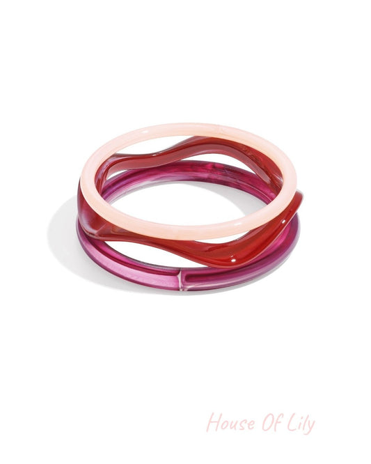 Two acrylic bangles in amber tortoise and clear amber stacked together on white background