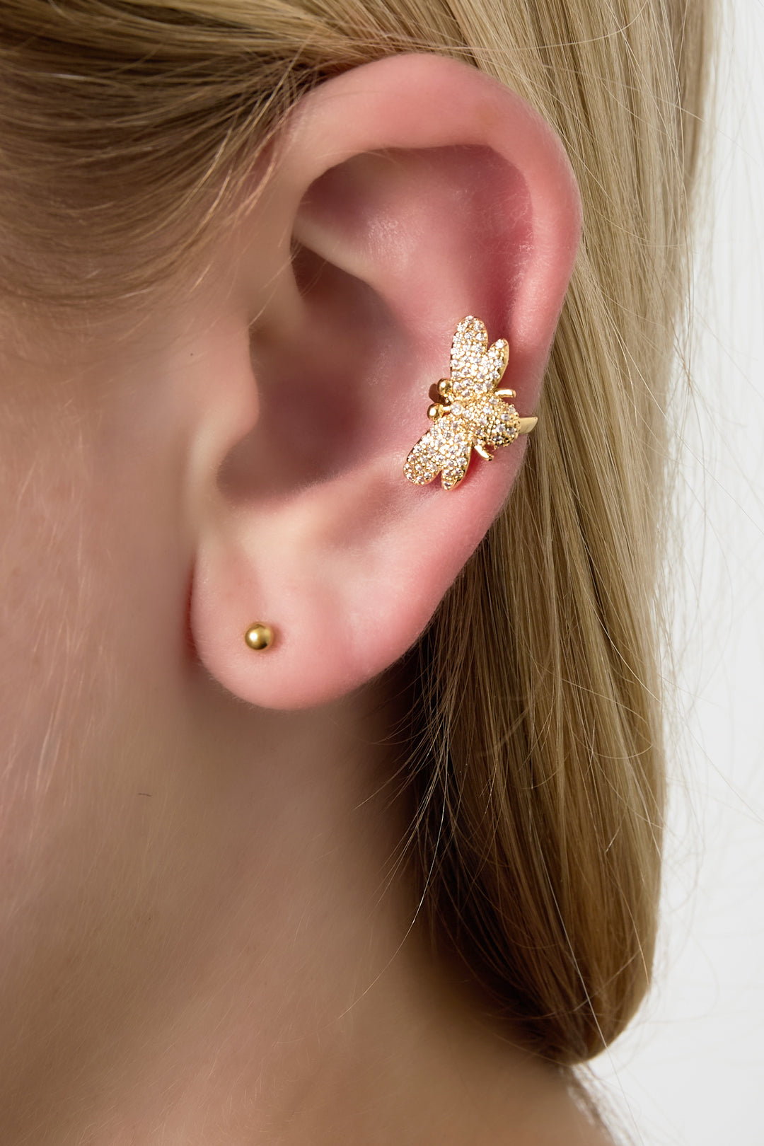 Model wearing the gold sparkling bee ear cuff clipped on the upper part of the ear