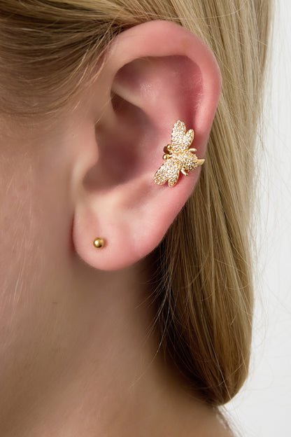 Model wearing the gold sparkling bee ear cuff clipped on the upper part of the ear