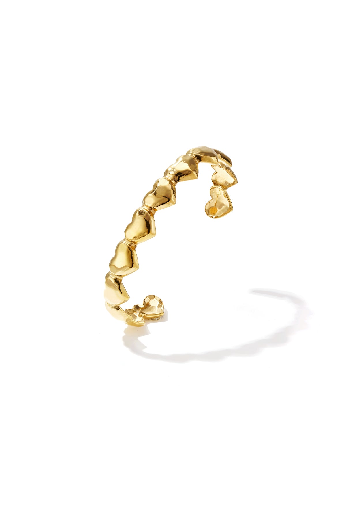 Gold dented heart cuff bracelet with open design on white background