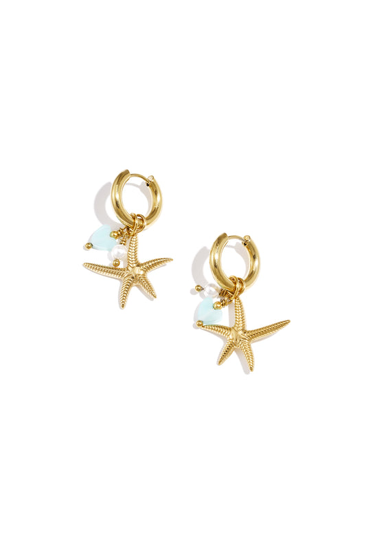 Pair of gold hoop earrings featuring textured starfish charms, pearl bead, and aqua heart charm on white background