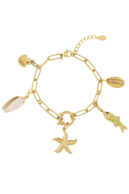 Gold chain bracelet with textured links featuring dangling ocean-themed charms: a starfish, shells, and a green fish.