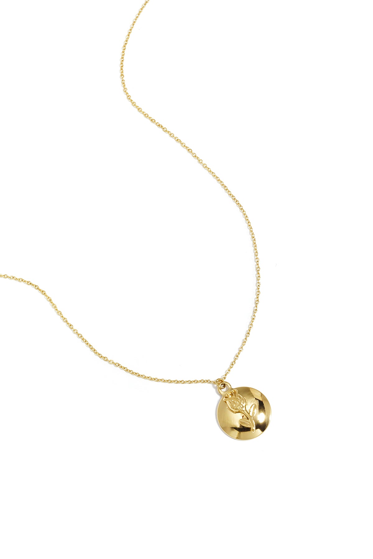 Gold pendant necklace featuring a flower embossed on a round shiny disc with delicate chain on white background
