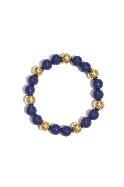 Single acrylic beaded bracelet featuring alternating deep blue and gold-tone beads isolated on white background