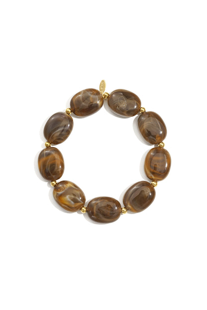Close-up of a coffee brown swirled acrylic beaded bracelet with gold spacers on white background