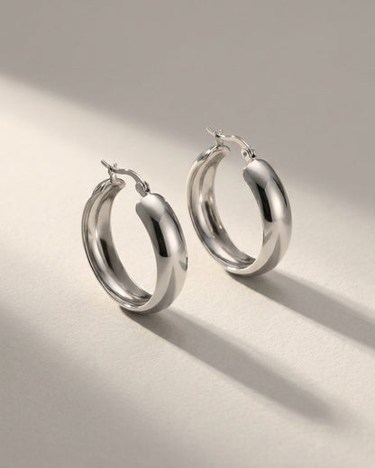 House of Lily silver-tone thick hoop earrings with a polished, minimalist finish on a neutral background.