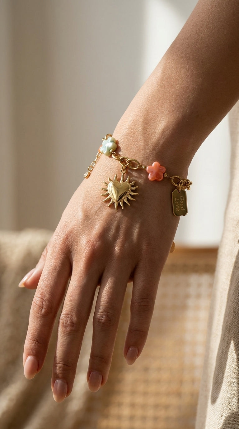 Charm Era Unlocked gold chain bracelet featuring a sun-heart pendant, colorful flower charms, and a Good Luck tag.