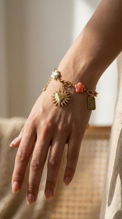 Charm Era Unlocked gold chain bracelet featuring a sun-heart pendant, colorful flower charms, and a Good Luck tag.
