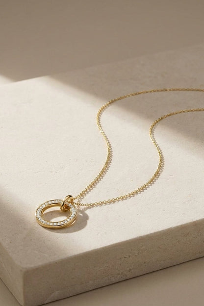 Gold Dual Tone Circle pendant necklace with pavé stones on a delicate chain.