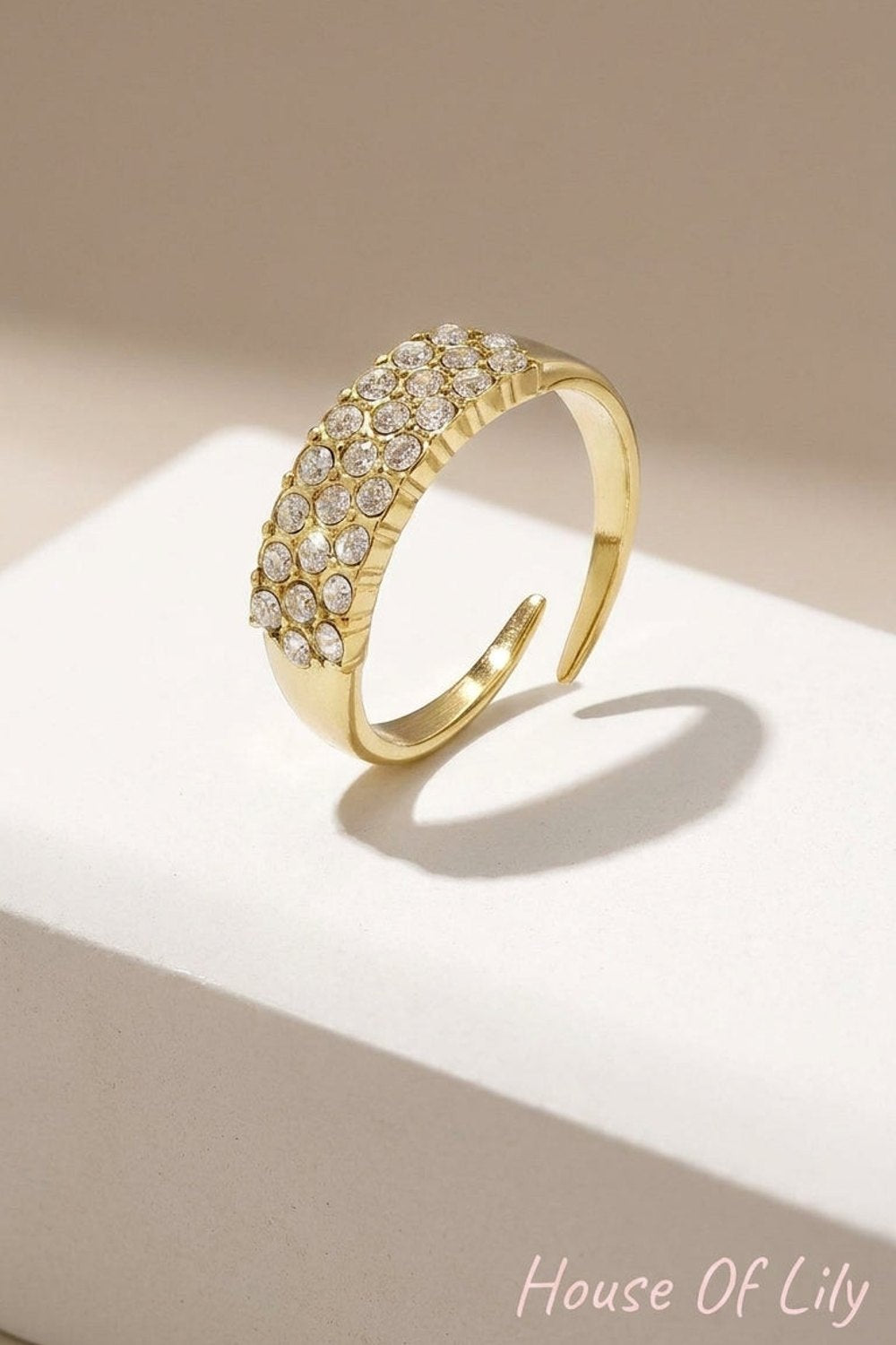 Minimalist gold-tone open ring featuring three rows of embedded rhinestones.