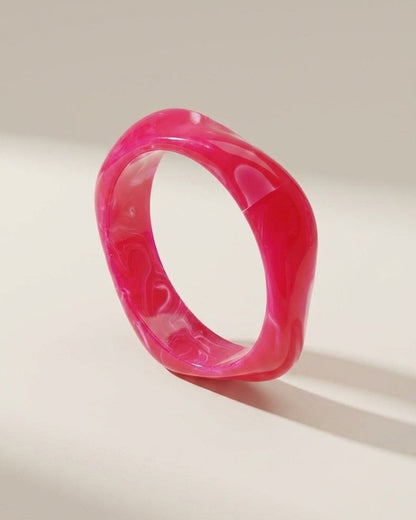 Hot pink acrylic statement bangle with a glossy, marbled finish and chunky style.