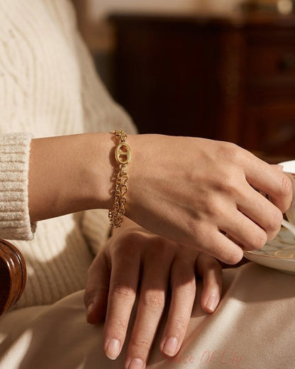 A gold multi-layered link bracelet is worn on a person's wrist.