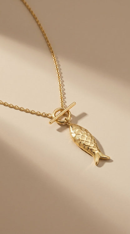 Catching Vibes gold necklace featuring a detailed fish pendant on a delicate chain with a front toggle clasp.
