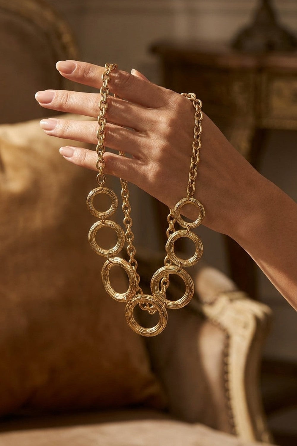 Gilded Chain Statement Necklace featuring interlocking gold-toned rings with textured details.