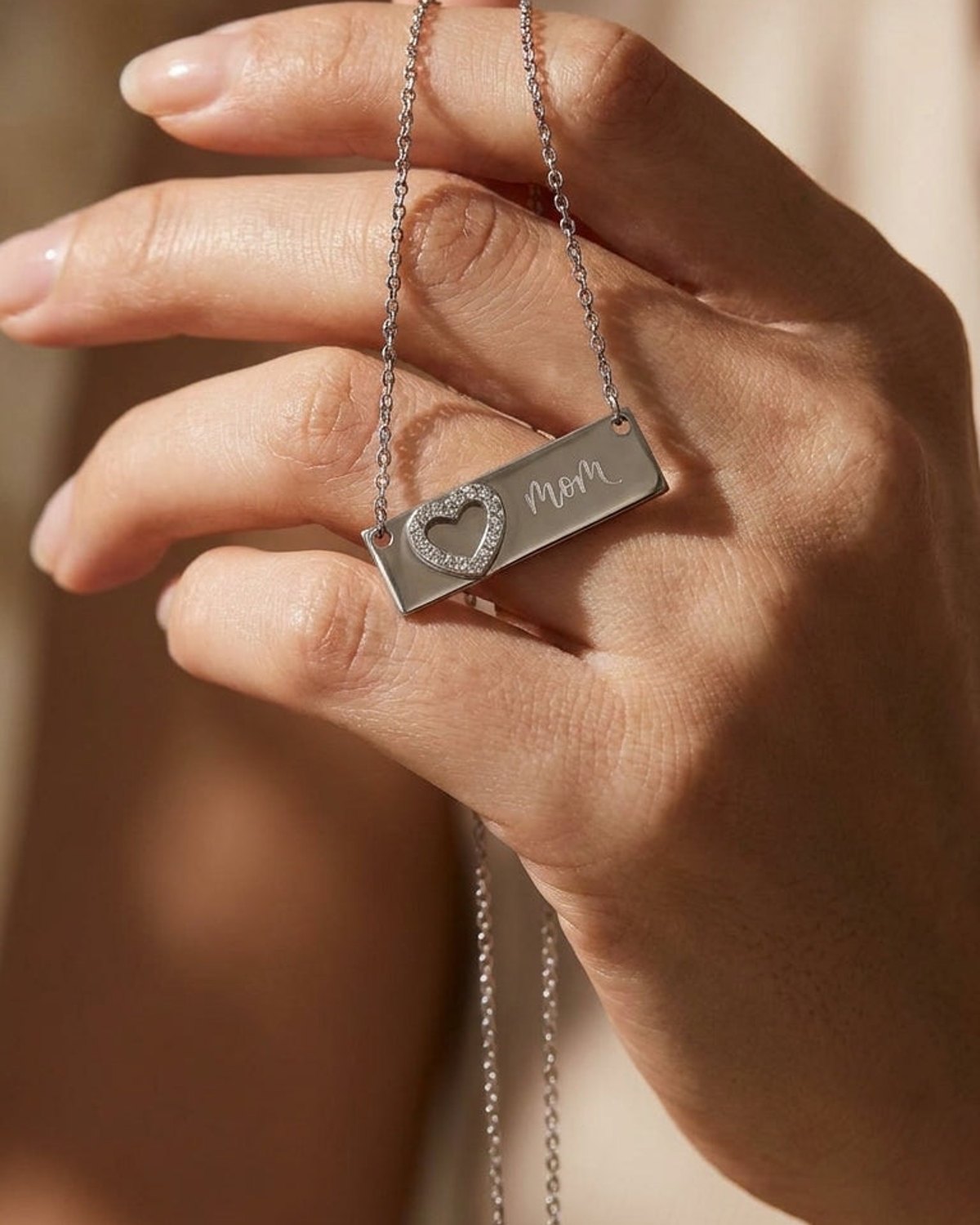 Silver-tone Heart Pendant Chain Necklace with a bar pendant engraved with "mom" and a crystal-set heart.