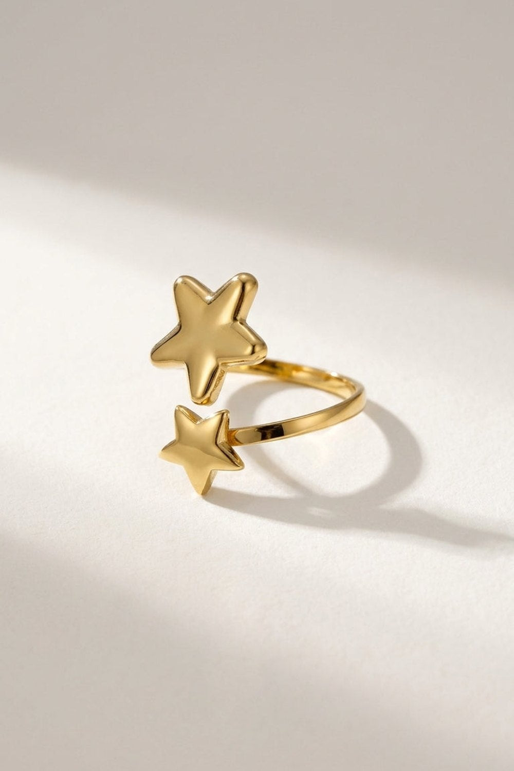 Gold minimalist star ring with an open band featuring a larger star and a smaller star.