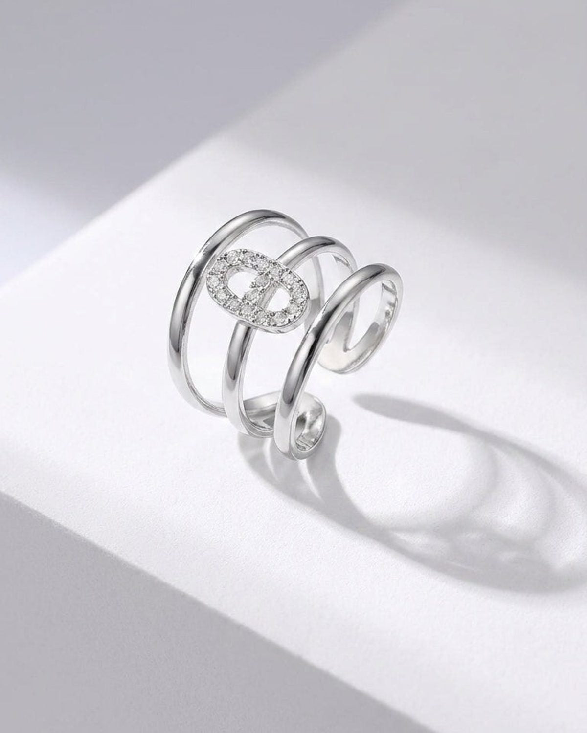 Silver multi-band statement ring with an elliptical, pavé-set crystal centerpiece.