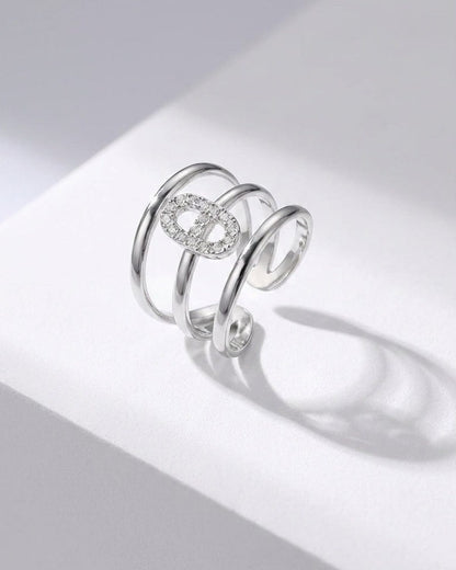 Silver multi-band statement ring with an elliptical, pavé-set crystal centerpiece.