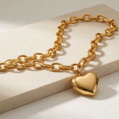 Gold-tone Heart Melter pendant necklace featuring a chunky, textured oval link chain and a smooth, puffy heart charm.